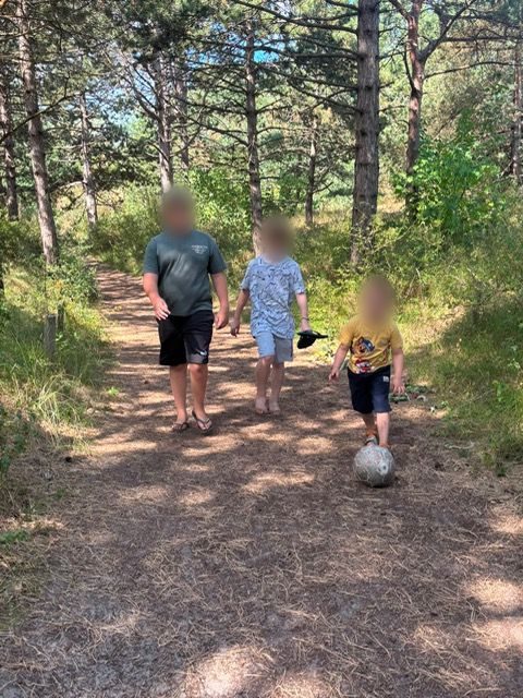 Kinderen lopen met een bal door het bos