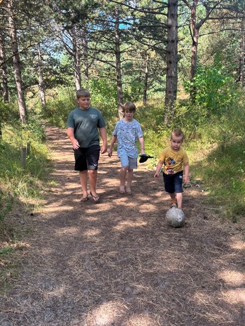 Kinderen lopen met een bal door het bos