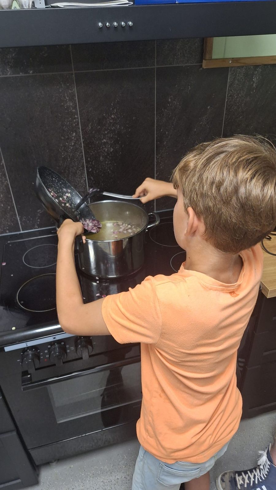 Een jongen kookt in de keuken